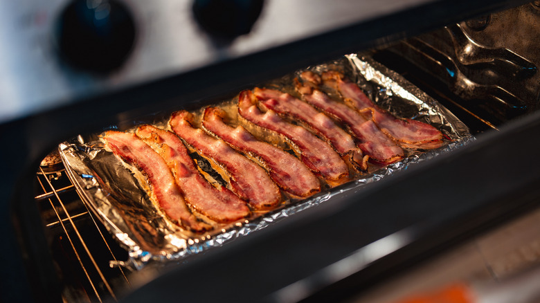 Bacon cooking in the oven on foil-lined pan