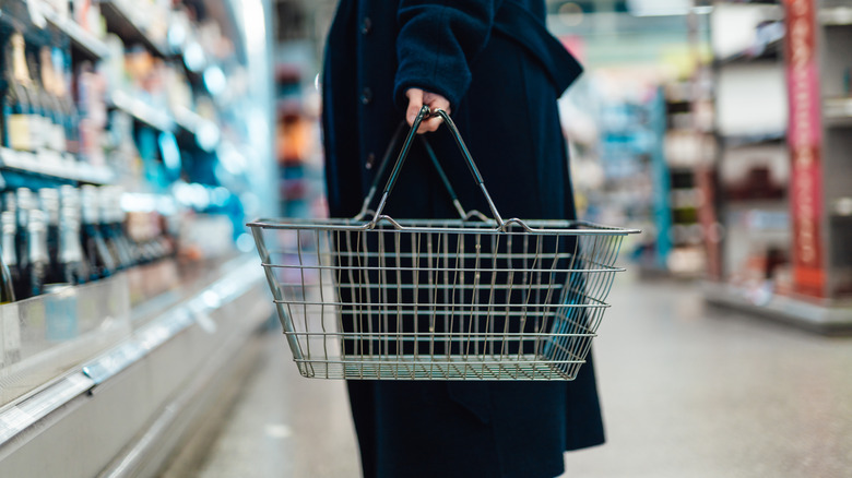 Person holds an empty grocery cart