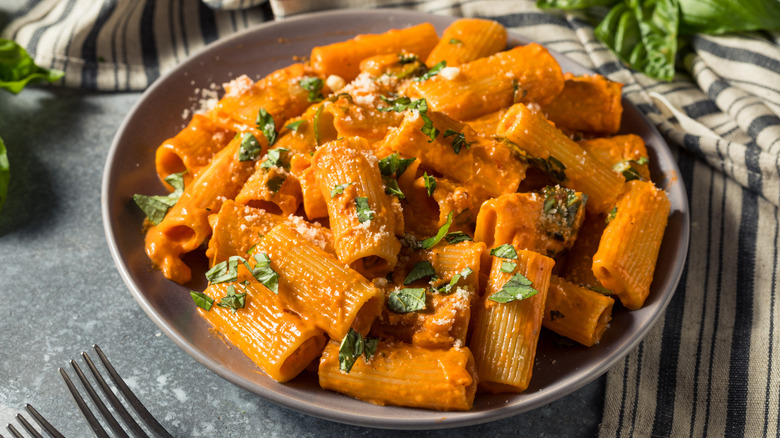 Homemade vodka rigatoni pasta with parmesan and basil in a bowl