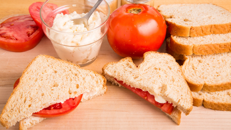 Ingredients for a Southern tomato sandwich on a wooden board.