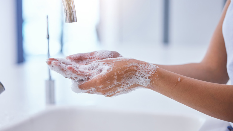 A person washing their hands in a sink.