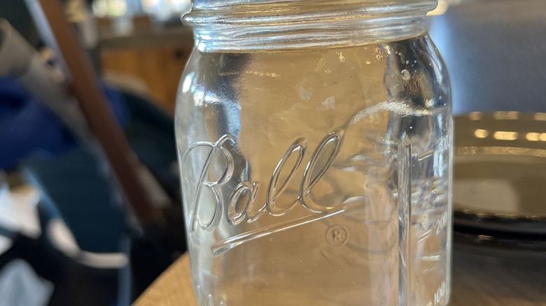 An empty, clear Ball Mason jar.