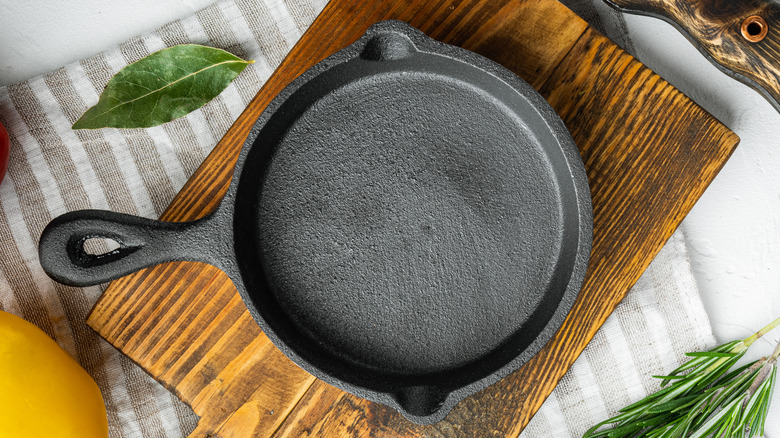 An empty cast-iron pan on a wooden surface.