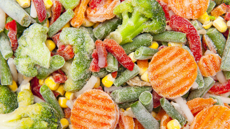 Close-up of assorted frozen vegetables such as carrots, broccoli, corn, and bell peppers.
