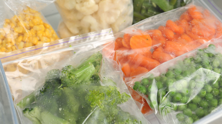 Frozen vegetables — brocolli, corn, carrots, cauliflower — packed in clear freezer bags.