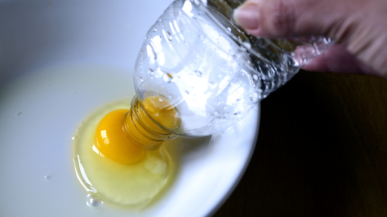 Suctioning an egg yolk from its whites using an empty plastic water bottle