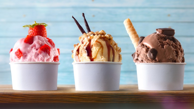 Various ice cream flavors in cups with garnishing