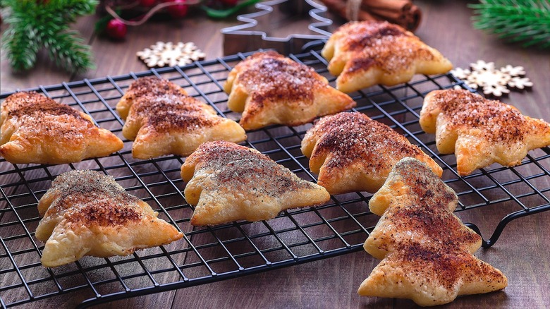 Christmas tree pie dough cookies with cinnamon sugar on a metal cooling rack