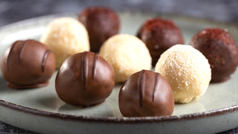 Closeup of white and dark chocolate truffles on a ceramic plate