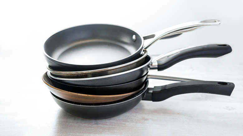 Various skillets stacked on top of one another