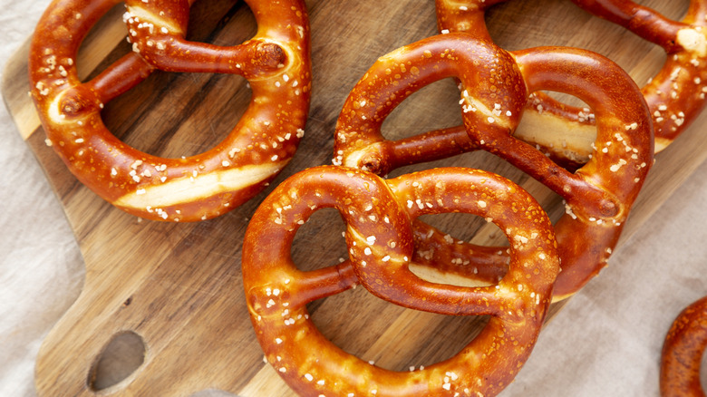 Top-down view of homemade soft pretzels on a wooden cutting board