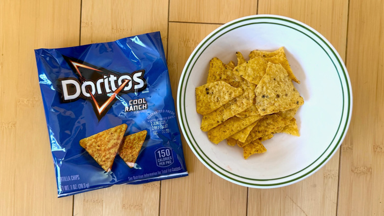 Bag of Cool Ranch Doritos beside filled bowl of chips