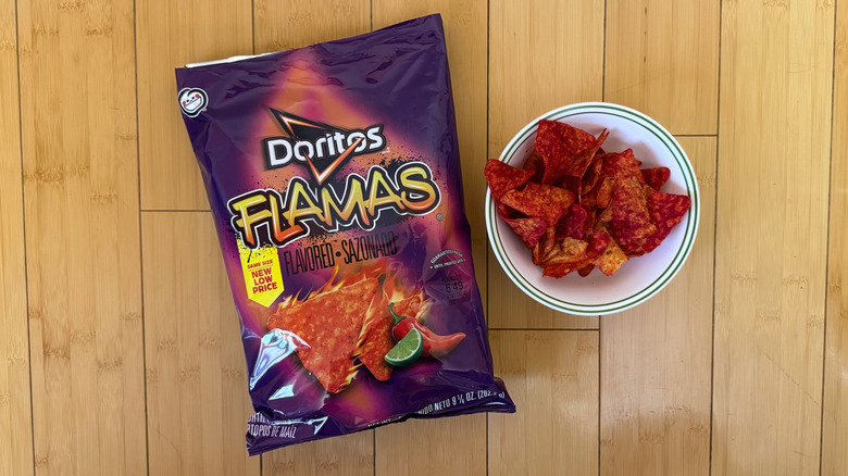 Bag of Flamas Doritos beside filled bowl of chips