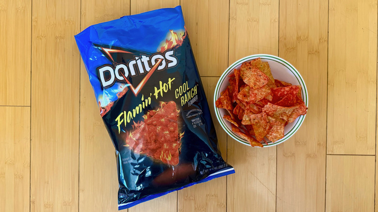 Bag of Flamin' Hot Cool Ranch Doritos beside filled bowl of chips