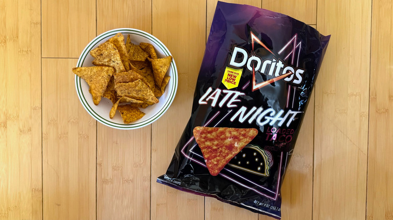 Bag of Late Night Loaded Tacos Doritos beside filled bowl of chips