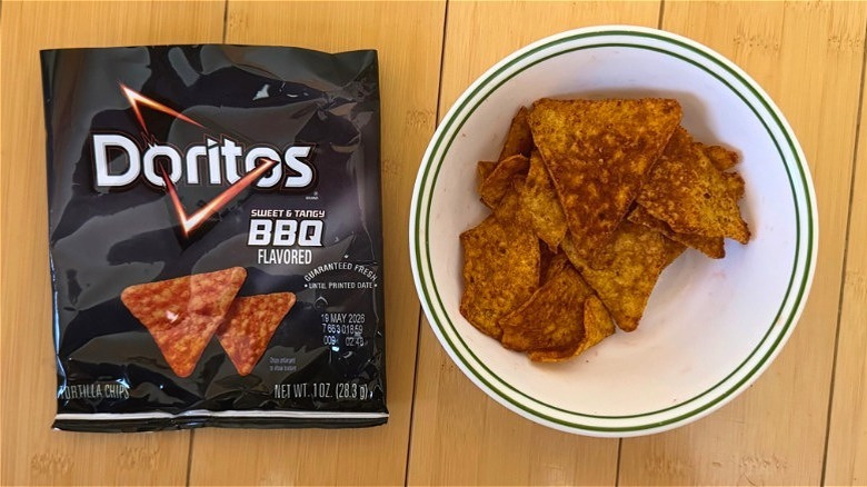 Bag of Sweet & Tangy BBQ Doritos beside filled bowl of chips