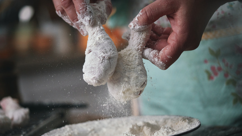 Preparing crispy fried chicken drumsticks.