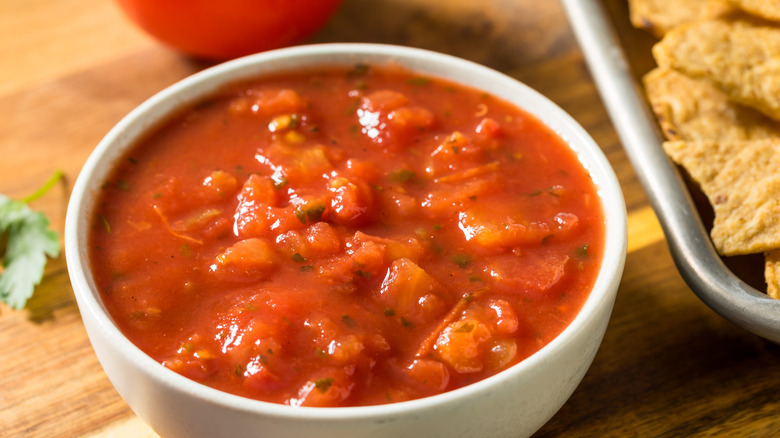 classic tomato salsa in a white bowl with tortilla chips