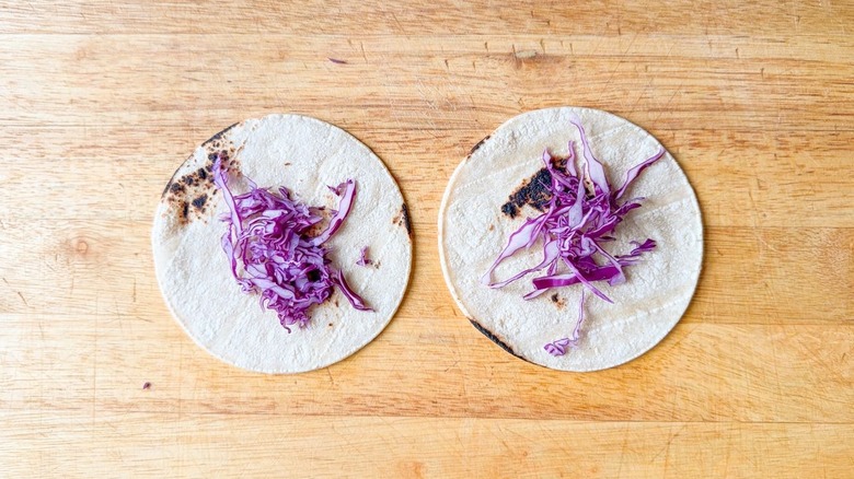 Shredded purple cabbage on corn tortillas