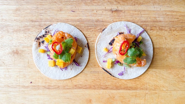 Dynamite shrimp tacos on cutting board