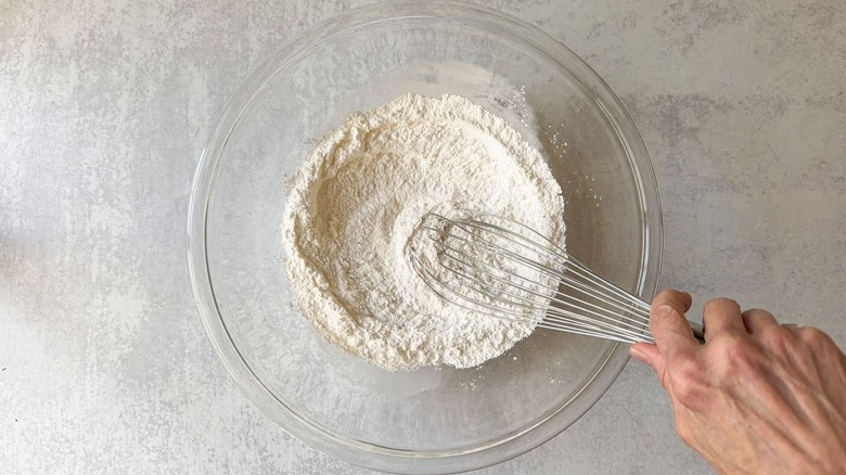 Whisking dry ingredients for shrimp batter in glass bowl