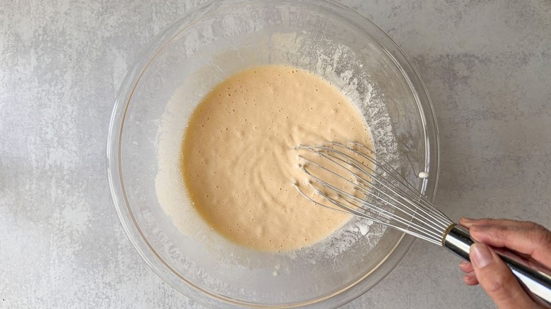 Whisking dynamite shrimp batter in glass bowl