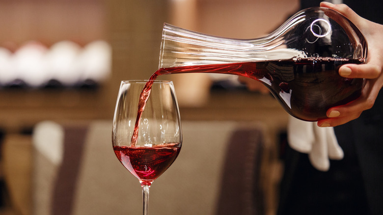 Pouring red wine from a decanter into a glass