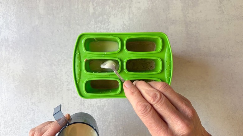 Adding sweetened condensed milk to Vietnamese coffee popsicles in molds
