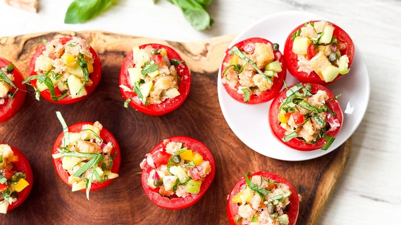 Mini panzanella salad-stuffed tomatoes on a board