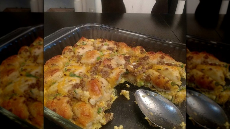 Glass pan of egg and biscuit casserole with one slice removed.
