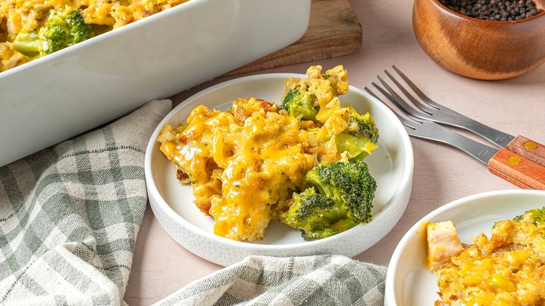 Portions of a cheesy broccoli and chicken casserole on small white plates