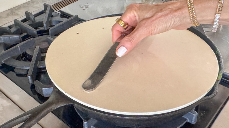 hand covering pan with lid