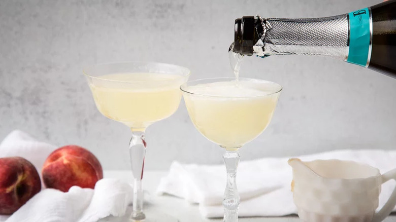 Classic Peach Bellinis being topped up with Prosecco