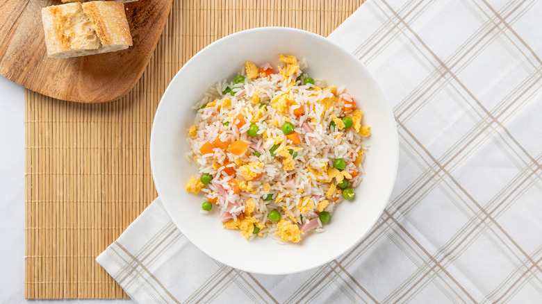 A bowl of egg fried rice laid over a table cloth