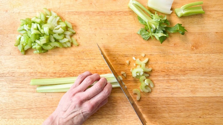 Slicing celery stalks on cutting board