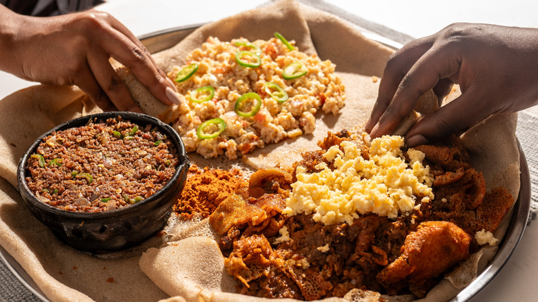 People eating Ethiopian breakfast firfir with scrambled eggs