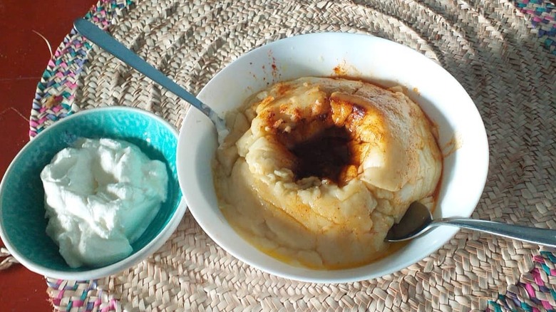 A bowl with genfo and two spoons next to a bowl with cheese