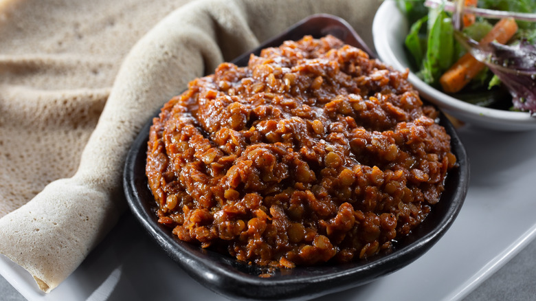 A bowl of misir wat with injera and salad