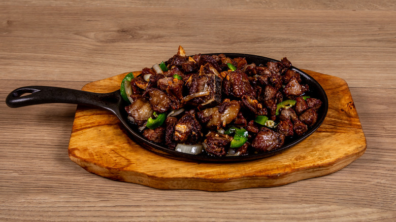 Ethiopian beef tibs in a sizzling cast iron platter