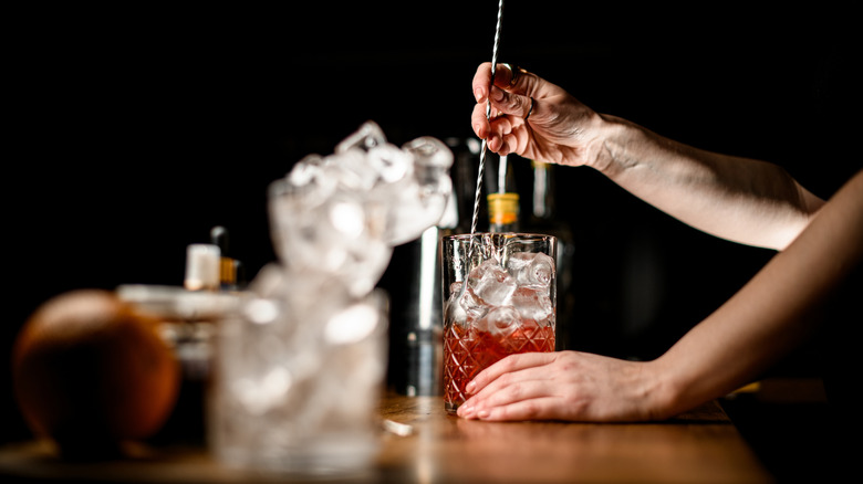 stirring a cocktail in a mixing glass