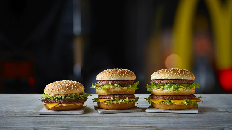 Three different sizes of Big Macs next to each other on a table