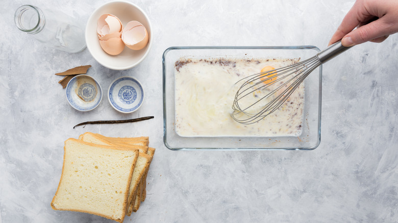 Overhead angle of a person making French toast and whisking the ingredients for custard