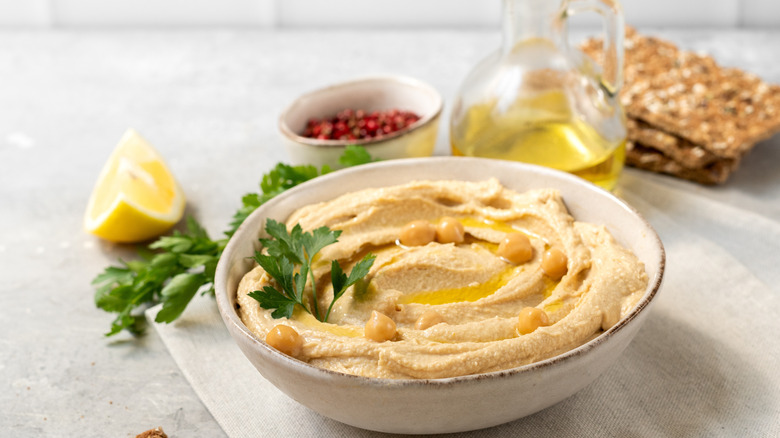 Bowl of hummus with lemon, pepper and olive oil