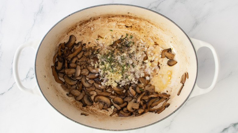 Large dutch oven with sauteed mushrooms, fresh garlic, shallot, and herbs