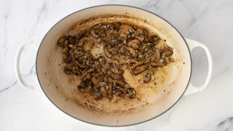 Dutch oven with sauteed mushrooms and white wine
