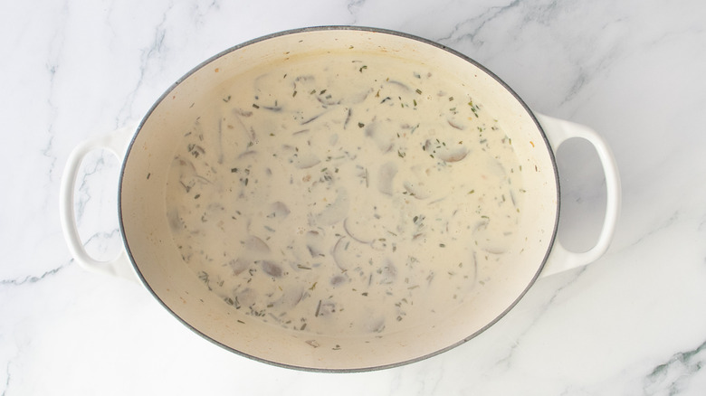 Dutch oven with mushrooms, cream, and broth