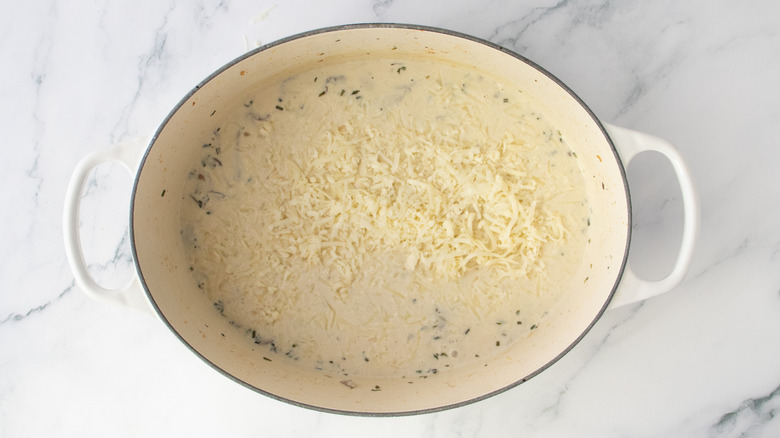 Dutch oven with mushrooms, cream, broth, and assorted white cheeses