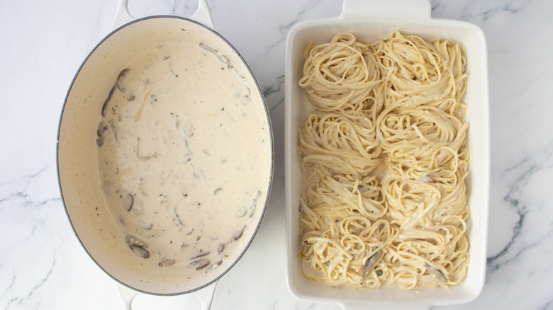 Dutch oven with creamy mushroom sauce and casserole dish with twirled noodles