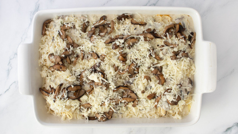 Creamy noodles, cheese, and sauteed mushrooms in a casserole dish