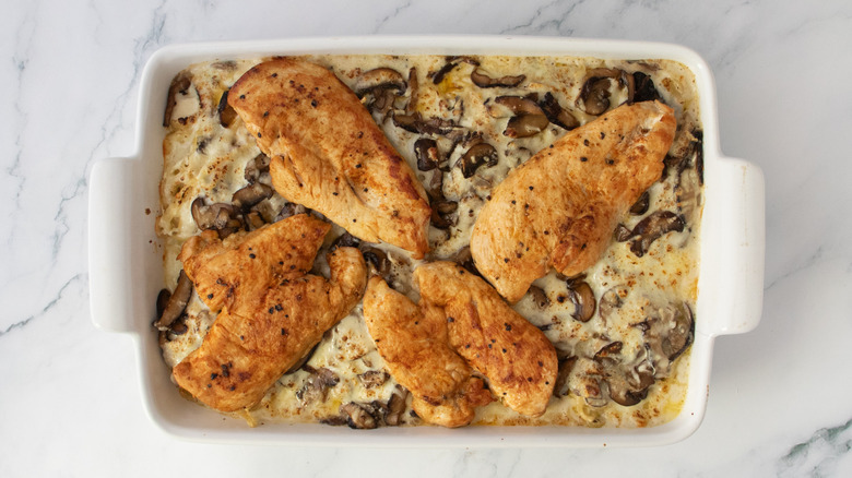 Baked noodle casserole dish topped with seared chicken